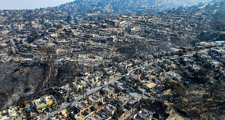 Flygfoto över många förstörda och brända hus.
