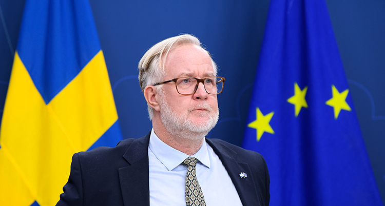 Johan Pehrson framför EUs och Sveriges flaggor.