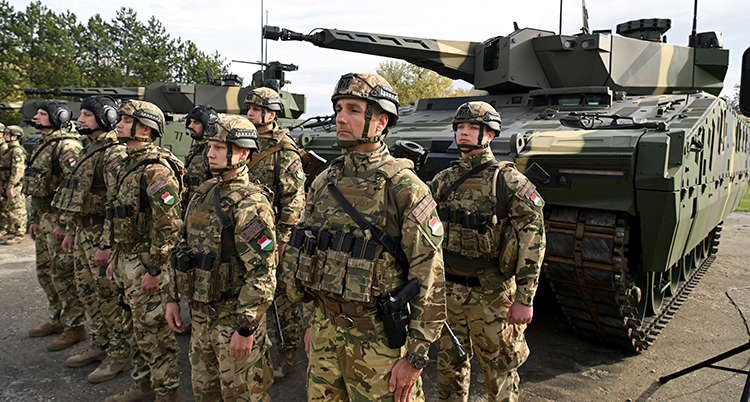 En grupp soldater framför en stridsvagn.