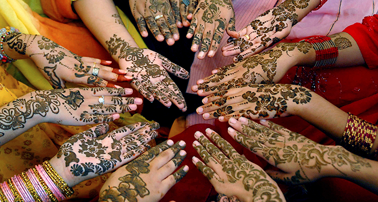 Flera flickor håller fram sina händer. På händerna är det målat med färg i olika mönster.