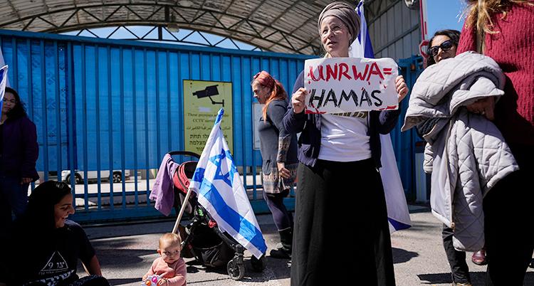 En kvinna med en skylt Unwra = Hamas står det.