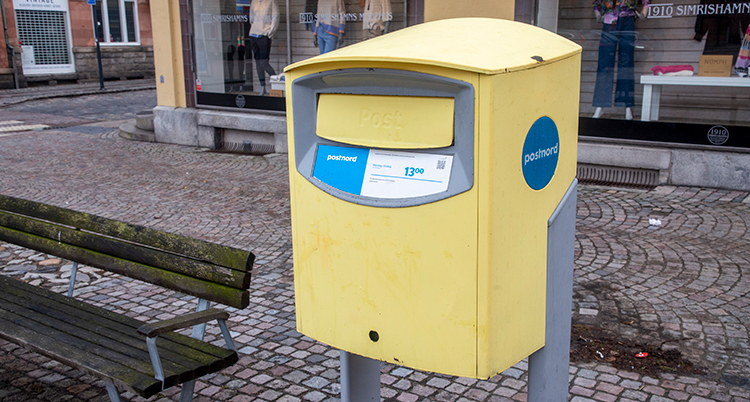 En gul brevlåda i en stad.