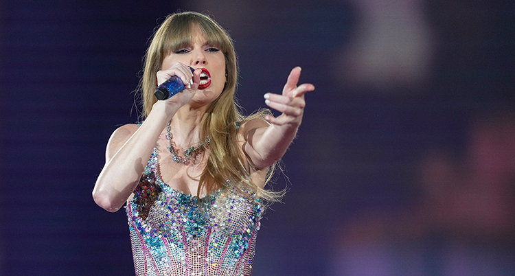 Taylor Swift sjunger och sträcker ut en hand.