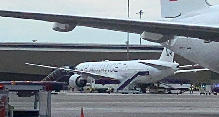 Ett flygplan står parkerat vid en flygplats.