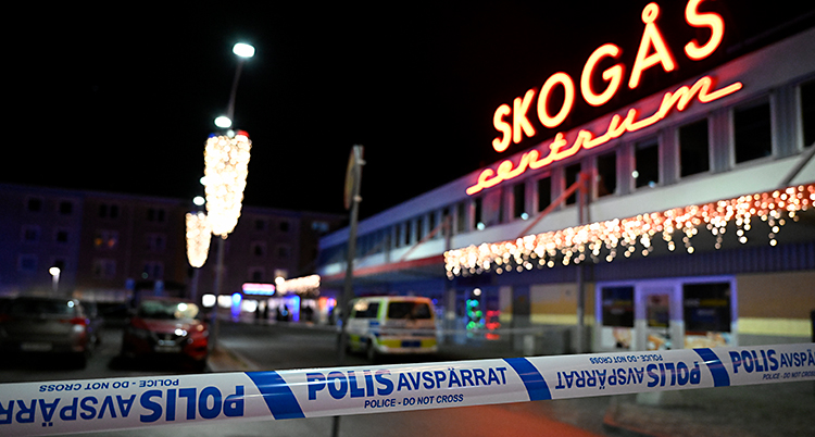 Det är mörkt ute. Poliserna har spärrat av vid Skogås centrum.
