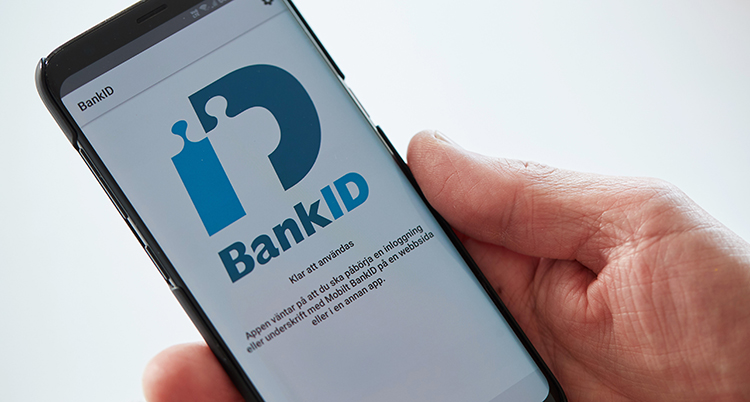 En hand håller en mobil som öppnat appen bank-id.