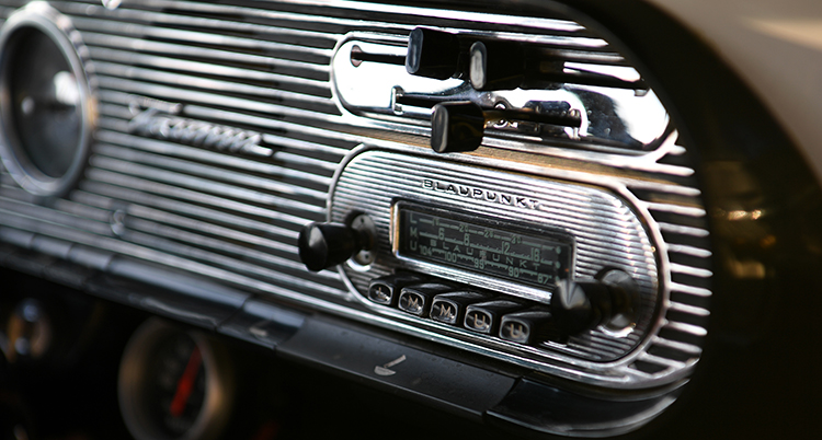 En silvrig instrumentbräda i en bil med bilradio.