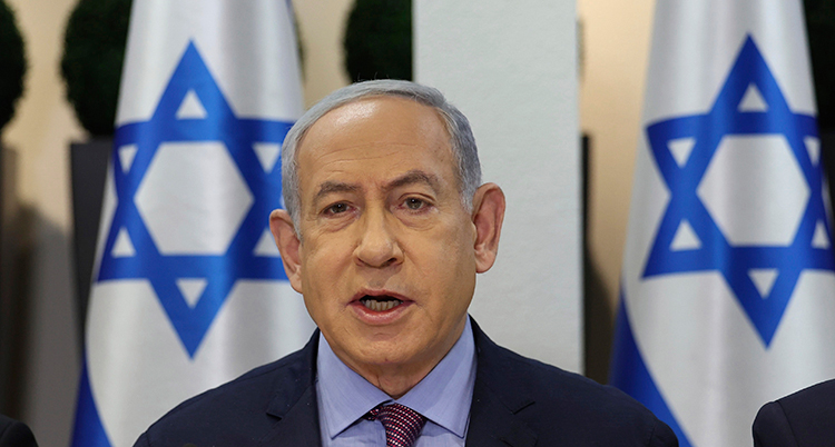 Hans huvud syns mellan två israeliska flaggor.