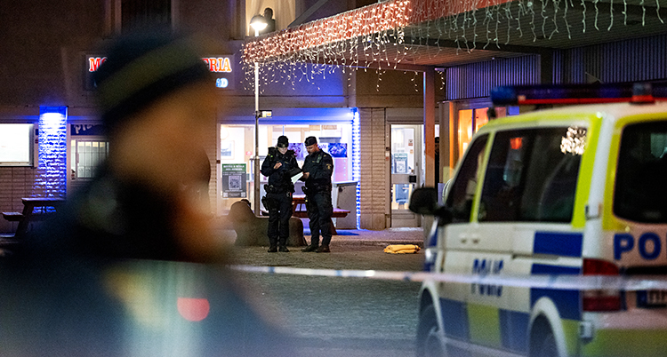 Poliser och en polisbil står utanför en restaurang i Skogås centrum.