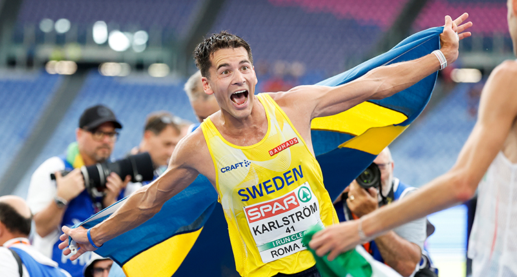 Han jublar och håller ut en svenska flagga bakom ryggen.