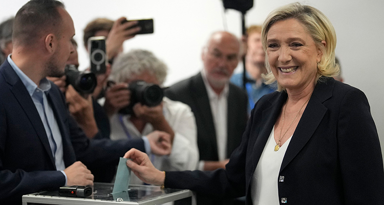 Le Pen ler och stoppar ett papper i en låda.