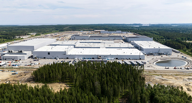 En stor fabrik med skog runtom. Fotograferad lite ovanifrån.