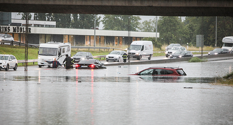 Massor med vatten på vägen och bilar som har vatten upp över fönstren.