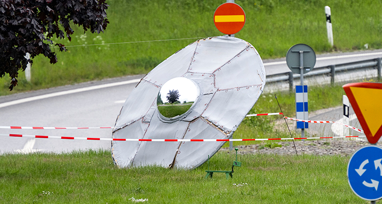 Något som ser ut som ett flygande tefat som har kraschat i en rondell. Tefatet är runt och silvrigt i färgen.