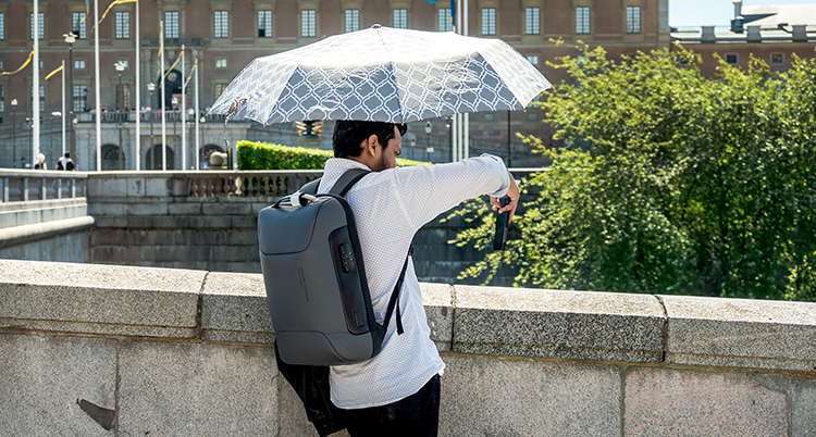 En man står i staden under ett paraply