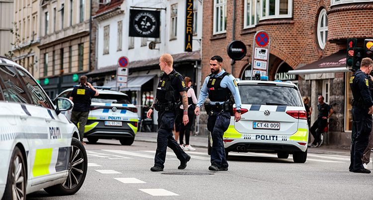 Flera poliser och polisbilar är på en gata i staden Köpenhamn.