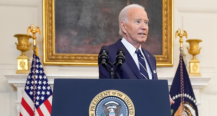 Joe Biden i en talarstol. Bakom honom är USAs flagga.