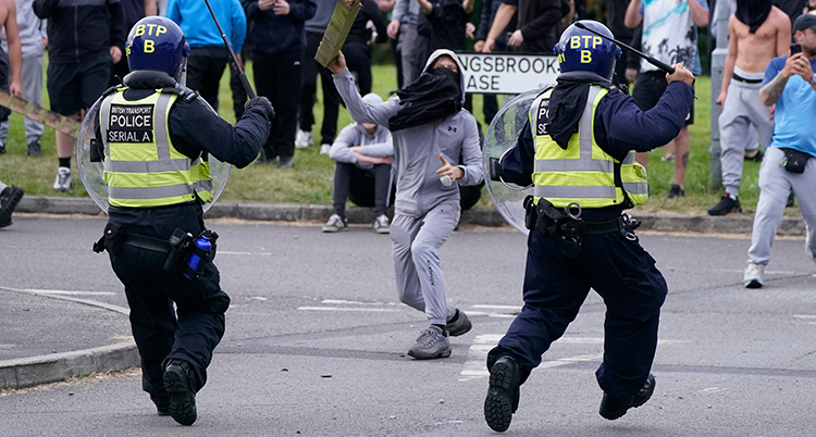 Två poliser springer mot en maskerad man.