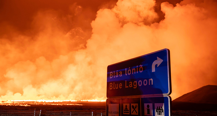 Massor av rök syns på himlen bakom en skylt som det står Blå lagunen på.