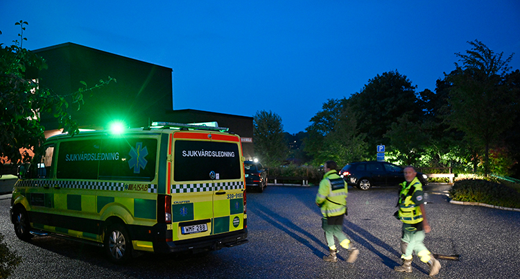 Det är mörkt. En ambulans och personal syns.