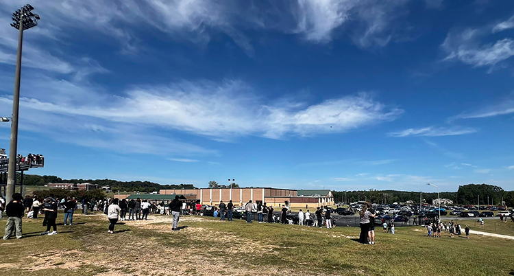 Människor står utanför en skola.