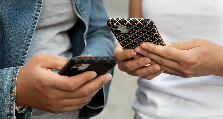 Två personer håller i varsin telefon.