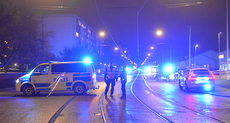 Det är mörkt. Några poliser står vid spåren till spårvagnen i Norrköping.