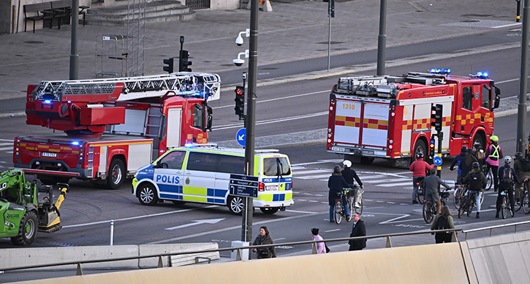 Brandbilar och polisbilar bland människor som cyklar.