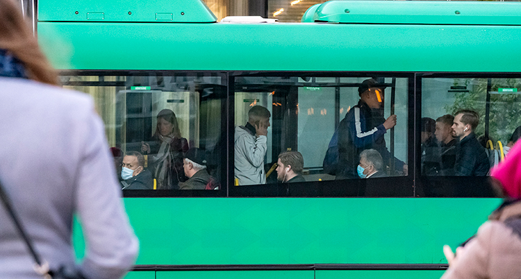 En grön buss med folk ombord.