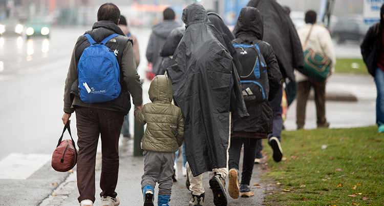 Flera personer går på en trottoar.