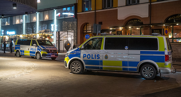 Två polisbussar står på på en gata.