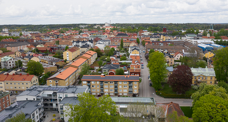 En bild från luften. Det syns många hus, vägar och skog.