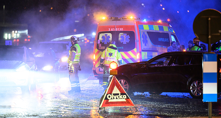 Det är mörkt. En ambulans och personal syns på vägen.