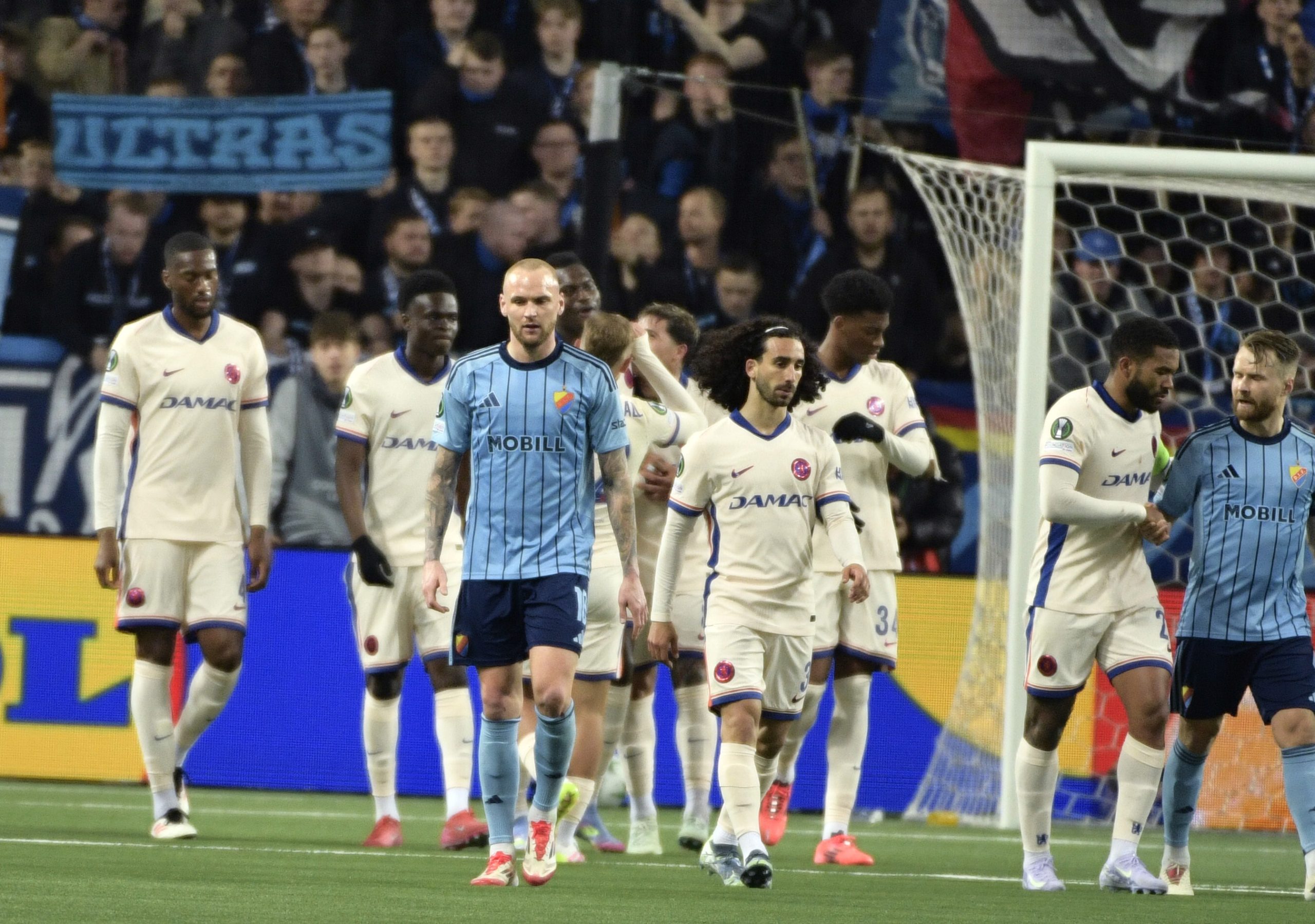 Spelare går på en fotbollsplan.