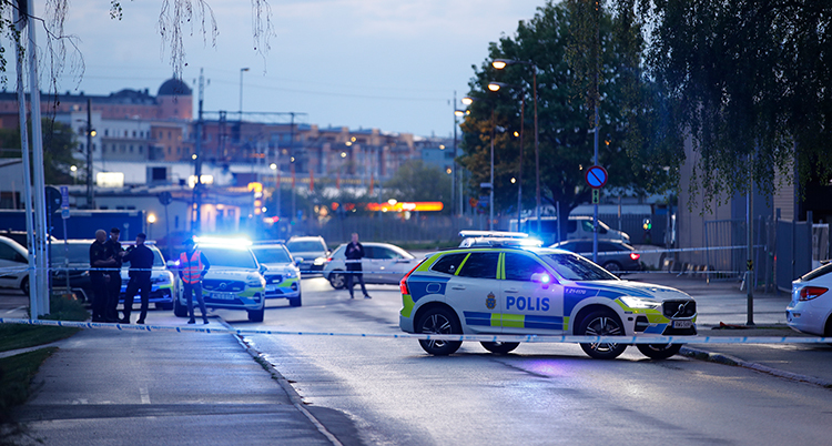 Poliser, polisbilar och polisernas tejp syns tydligt.