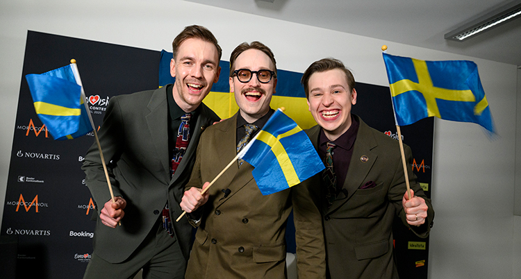 Kaj vinkar med svenska flaggor.