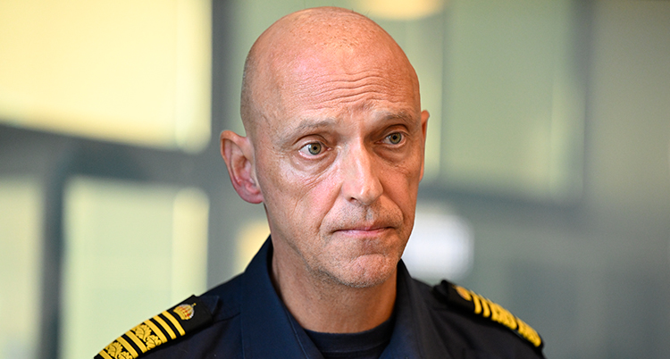 Porträtt på en skallig man i polisuniform.