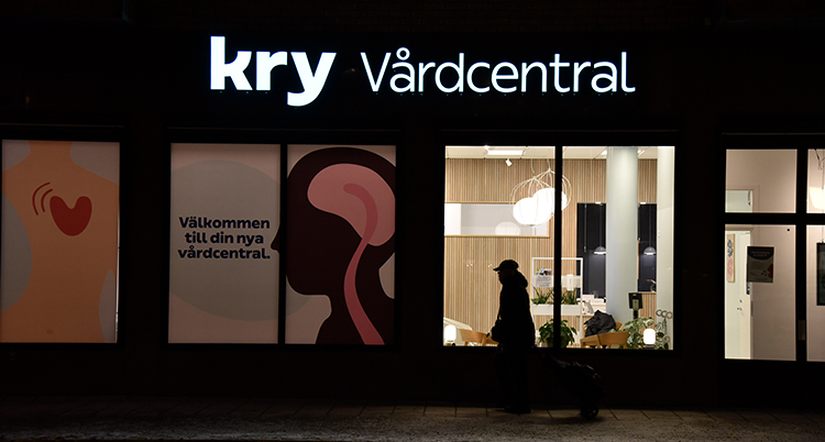 En person går utanför en av Krys vårdcentraler i Stockholm. Det är kväll.