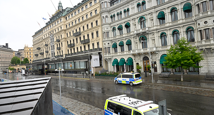 Två polisbilar syns utanför hotellet som är ett stort gammalt hus i sten.