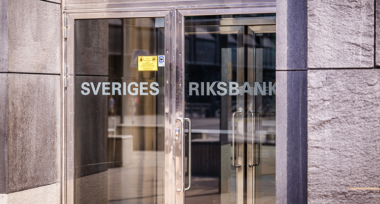 En bild på riksbankens dörrar i entrén. Det står riksbanken på dörrarna.