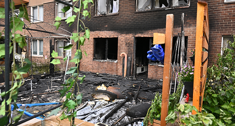 En uteplats vid ett hus med lägenheter har brunnit.