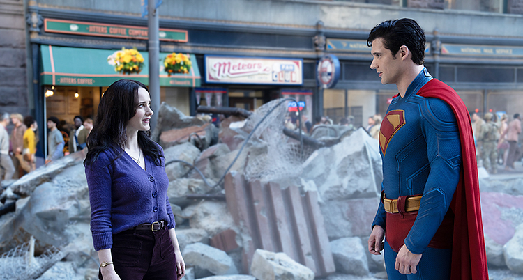 Reportern Lois Lane tittar på stålmannen som har sin dräkt med sitt märke på sig.