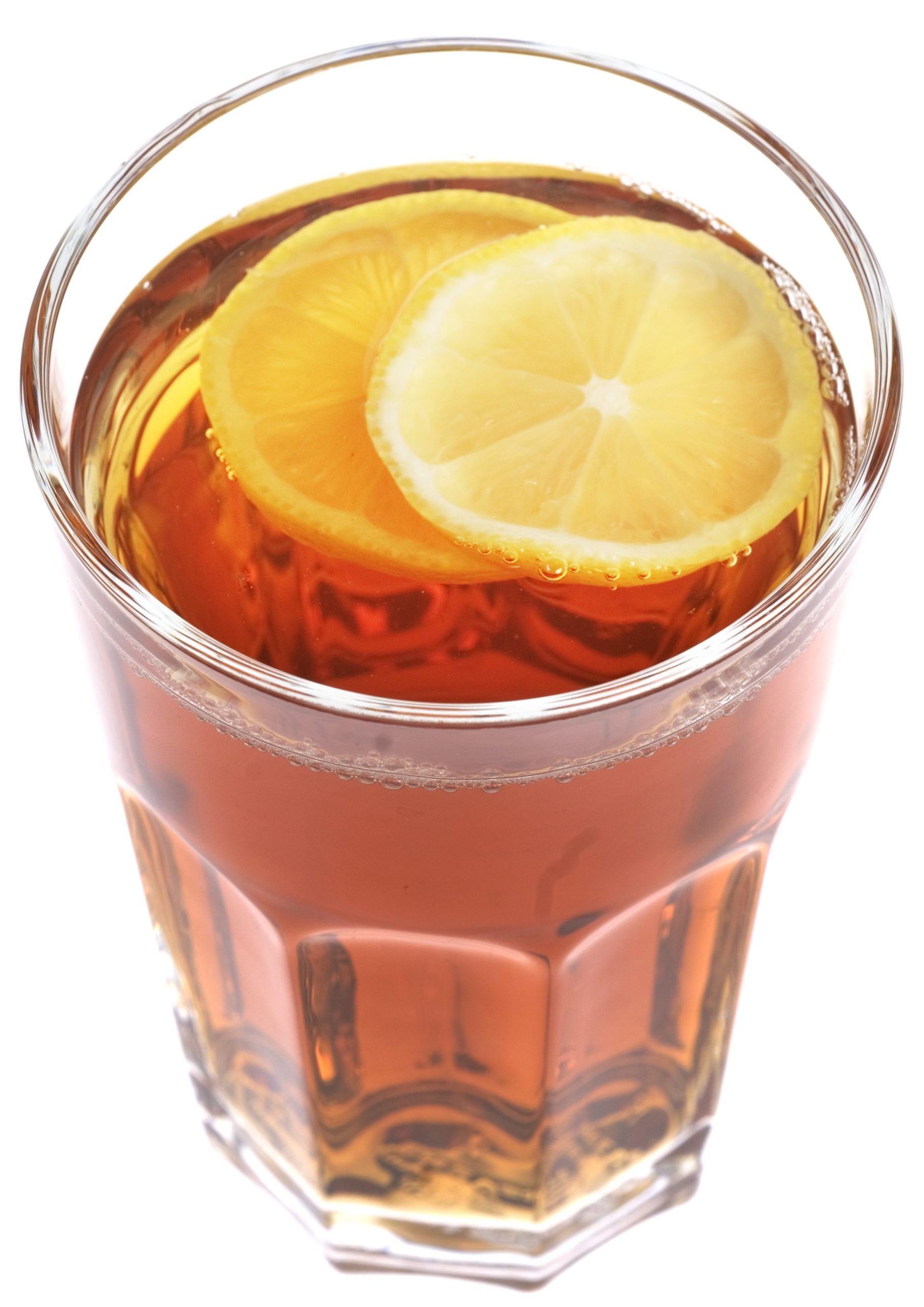 Ett glas med te och två skivor citron.