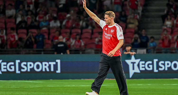 Ensam spelare på en fotbollsplan. Han vinkar till publiken.