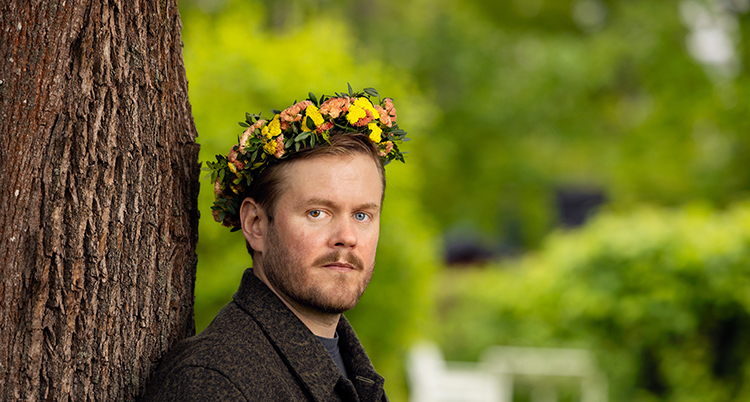 Han har en krans med blommor på huvudet.