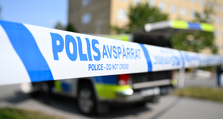 Tejp som det står avspärrat på. En polisbil.