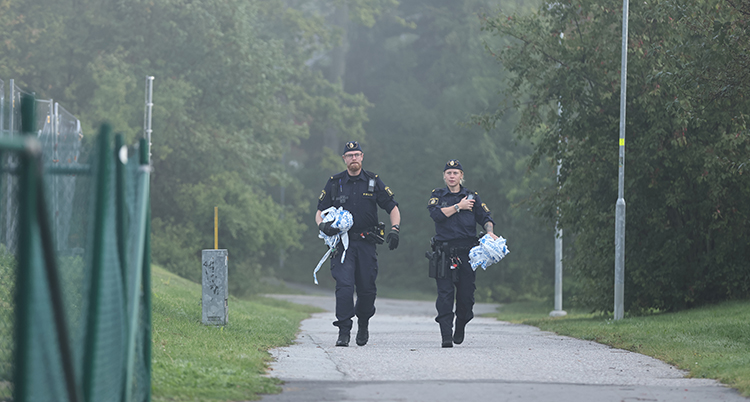Två poliser går på en gångväg.