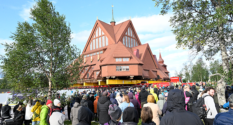 Kyrkan står på ett flak. Många människor står framför och tittar.