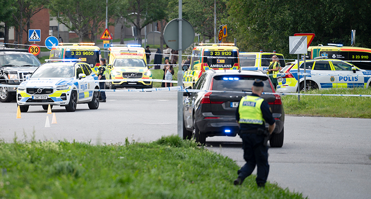 Flera polisbilar och ambulander. Polisband spärrar av.