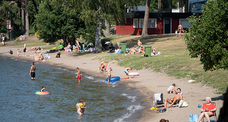 Människor badar vid en strand.